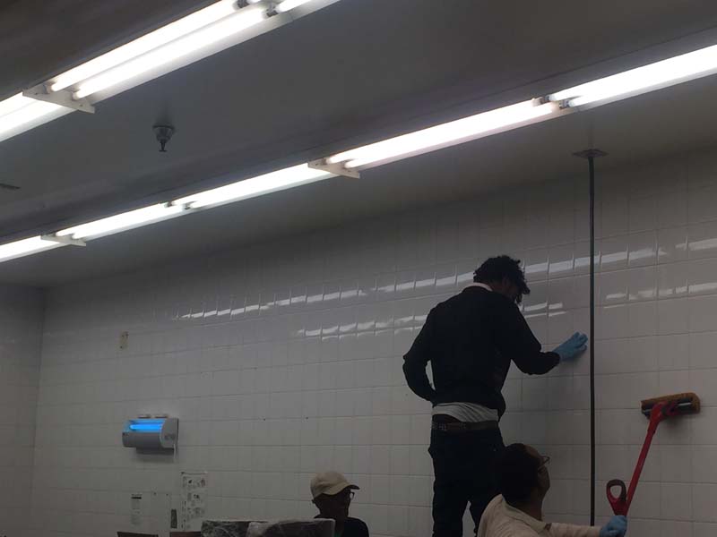 People cleaning tile wall
